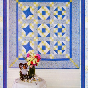 May include: A quilt pattern called "Stepping Stones" featuring a blue and yellow patchwork design with a star motif. The pattern is from Patchwork Schoolhouse 2016.