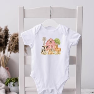 Könnte beinhalten: Weißer Baby-Body mit einer Aquarell-Illustration eines roten Bauernhofs, einer Windmühle und Hoftieren. Das Design umfasst eine Kuh, ein Schaf und ein Pferd. Der kurzärmelige Body hängt an einem weißen Kleiderbügel.