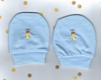 May include: A pair of light blue baby mittens with embroidered floral designs and a small golden bell on each mitten.