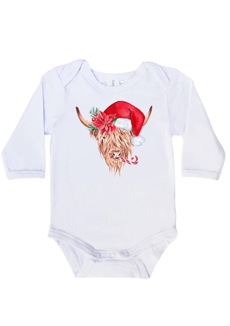 May include: White long-sleeved baby onesie featuring a watercolour illustration of a Highland cow wearing a Santa hat and holding a candy cane.