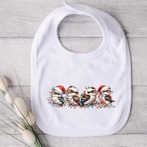Pode incluir: Babador de bebé de algodão branco com um design de Natal com quatro kookaburras de desenho animado usando chapéus de Papai Noel e segurando luzes de Natal.
