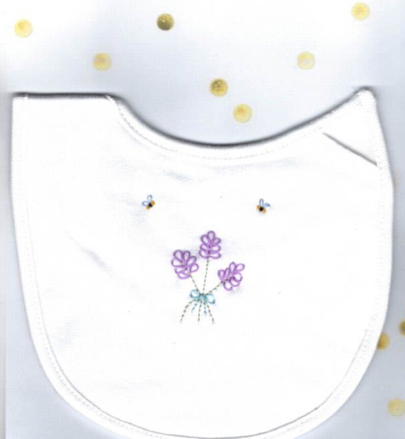 May include: White cotton bib with embroidered lavender flowers and bees in purple, blue, and green.