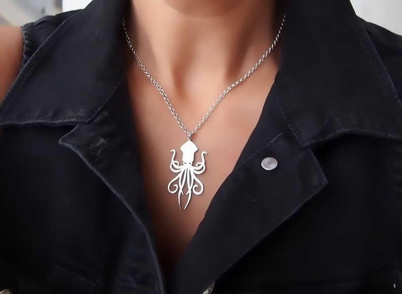 May include: A silver necklace with an octopus pendant. The octopus is a simple silhouette design.