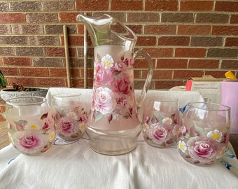 Handbemalter Milchkrug aus rosa Glas mit 4 Gläsern. Bemalt mit einem floralen Motiv mit rosa Rosen und weißen Füllblumen. Tolles Geschenk