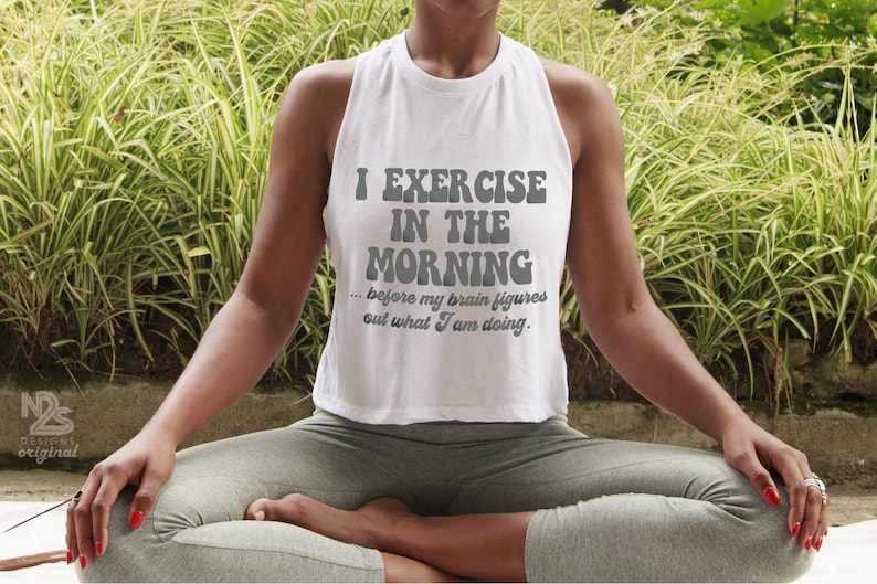 White cropped tank top with the phrase 'I Exercise in the Morning... before my brain figures out what I am doing.' Lightweight and funny activewear, perfect for yoga, gym, or New Year's fitness goals in 2025.