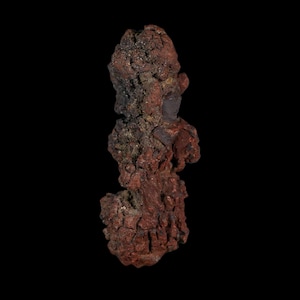 Peut inclure: Un spécimen minéral brut de formation naturelle avec une texture rugueuse et inégale. L'objet présente une coloration brun-rouge terreuse profonde avec des taches plus sombres, ton charbon, et une structure de surface poreuse et escarpée.