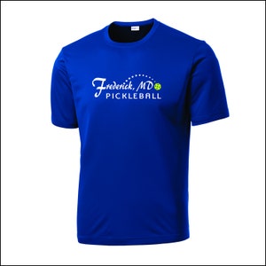May include: Royal blue performance t-shirt with a white graphic of the text "Frederick, MD Pickleball" and a green pickleball.