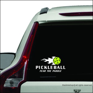 May include: A black and white car sticker with a yellow pickleball and flames. The text reads "Pickleball Fear the Paddle".
