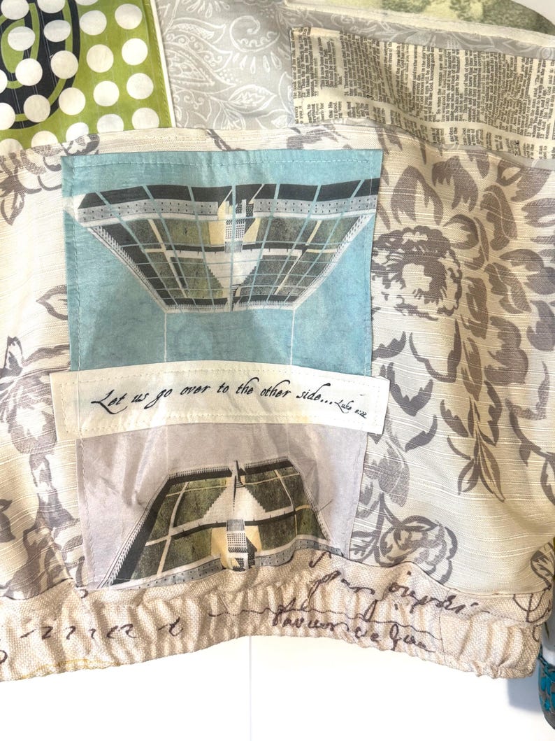 Pode incluir: Close-up de um tecido de patchwork com v&aacute;rios padr&otilde;es e texturas. Apresenta um bolso azul claro com uma ilustra&ccedil;&atilde;o de um edif&iacute;cio e o texto "Let us go over to the other side..." em escrita preta. O tecido inclui desenhos florais e de bolinhas.