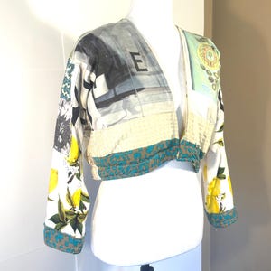 Pode incluir: Casaco curto com decote em V em um manequim. O casaco apresenta um design de patchwork com lim&otilde;es, estampas florais e desenhos abstratos. As mangas e a bainha s&atilde;o aparadas com um tecido estampado em azul-petr&oacute;leo e marrom. A letra "E" &eacute; vis&iacute;vel no casaco.