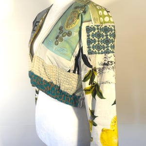 Pode incluir: Casaco curto patchwork com decote em V. O casaco apresenta uma variedade de padr&otilde;es de tecido, incluindo estampas de lim&otilde;es, formas geom&eacute;tricas e ilustra&ccedil;&otilde;es de estilo vintage. As mangas e a bainha s&atilde;o adornadas com tecido estampado em azul-petr&oacute;leo e castanho.
