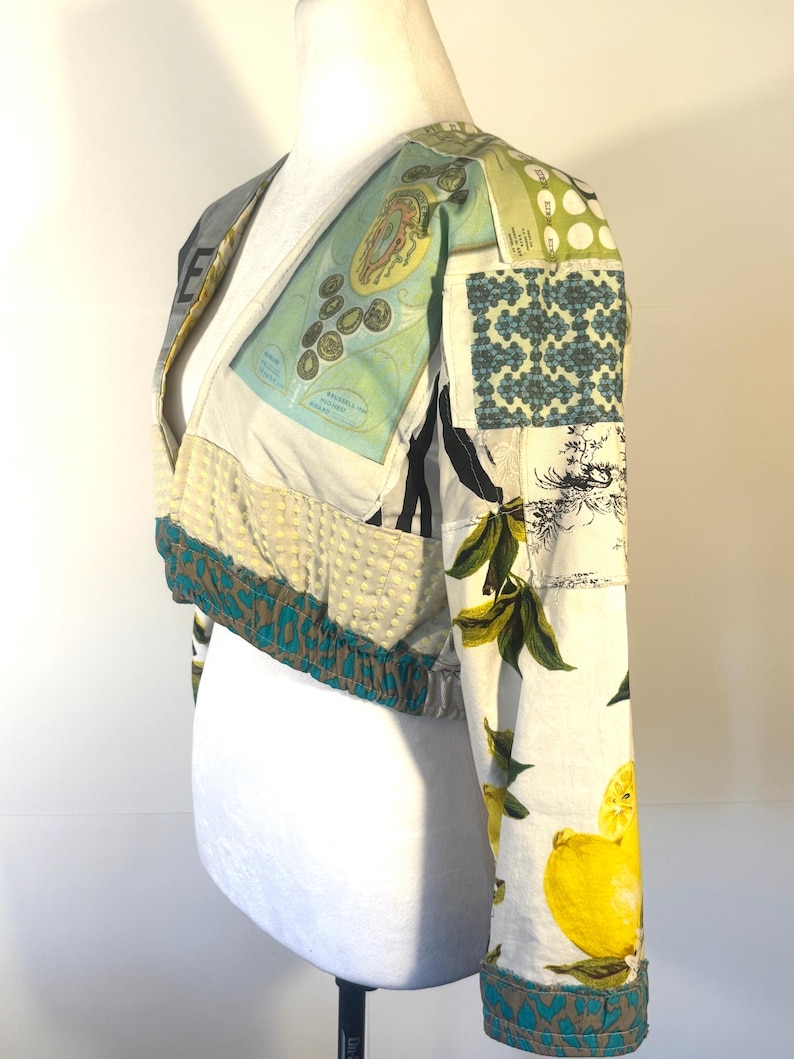 Pode incluir: Casaco curto patchwork com decote em V. O casaco apresenta uma variedade de padr&otilde;es de tecido, incluindo estampas de lim&otilde;es, formas geom&eacute;tricas e ilustra&ccedil;&otilde;es de estilo vintage. As mangas e a bainha s&atilde;o adornadas com tecido estampado em azul-petr&oacute;leo e castanho.