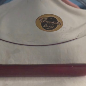 May include: A silver serving tray with a burgundy handle and a gold sticker that reads "Gourmate's, Quality at its best, Canada".