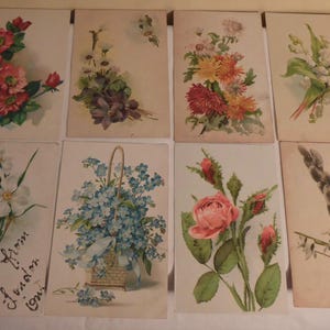 Può includere: Set di dieci cartoline floreali vintage con diversi fiori, tra cui rose, nontiscordardime, mughetti e rami di salice. Le cartoline sono stampate su carta color crema con un bordo marrone chiaro.