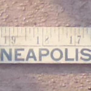 May include: A white wooden ruler with black markings and the text "Cockshutt - Minneapolis-Moline - Oliver".