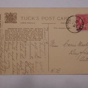 Pode incluir: Um cart&atilde;o postal vintage com uma fotografia a preto e branco de um parque com uma ponte e &aacute;rvores. O cart&atilde;o postal &eacute; endere&ccedil;ado &agrave; Srta. Carrie Maclauza em Bayfield, Ont&aacute;rio. O cart&atilde;o postal tem um selo canadiano de 2 c&ecirc;ntimos.