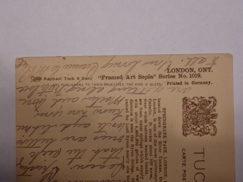 Pode incluir: Um cart&atilde;o postal vintage com uma fotografia a preto e branco de um parque com um rio e &aacute;rvores. O texto no cart&atilde;o postal diz "Springbank Park, London, Ontario. Localizado rio abaixo do rio T&acirc;misa, o London, &eacute; um dos mais pitorescos de Ont&aacute;rio. Cobre cerca de 300 acres, com nascentes de &aacute;gua doce que abastecem a cidade com cerca de 4.000.000 gal&otilde;es de &aacute;gua. &Agrave; dist&acirc;ncia, pode-se ver a ponte Byron, nomeada em homenagem a Lord Byron h&aacute; quase cem anos."