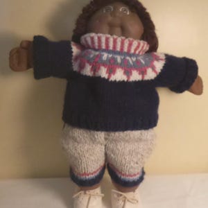 Poupée Cabbage Patch Kid vintage des années 1980, représentant une petite fille afro-américaine avec deux fossettes. Tenue tricotée à la main, signée Xavier Roberts (1978-1982). Copyright Coleco.