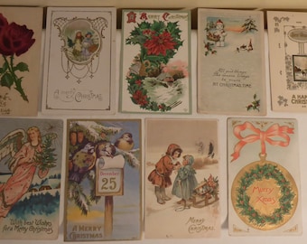 May include: A collection of ten vintage Christmas postcards featuring various festive themes, including a red rose, a poinsettia, a snowy scene, an angel, a wreath, and a child with a sledge. The postcards are printed on thick paper with colourful illustrations and greetings.