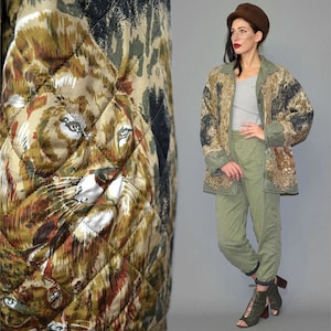 May include: A quilted jacket featuring a detailed lion print in shades of brown, tan, and black, paired with a light grey tank top, olive green trousers, a brown hat, and olive green lace-up open-toe shoes with block heels.