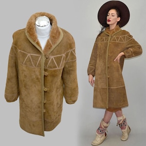May include: A brown suede coat with a shearling collar and geometric design on the front. The coat has a button-up closure and is knee-length. The coat is displayed on a mannequin and a person.