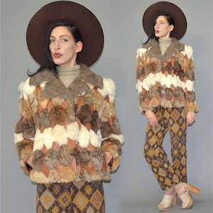 May include: A vintage fur jacket and matching trousers set. The jacket has a patchwork design in shades of brown, cream, and tan. The trousers feature a diamond pattern in similar colours. A wide-brimmed brown hat completes the ensemble.