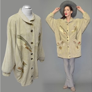 May include: Beige suede jacket with a button-up front, large pockets, and decorative patches. The jacket is displayed on a mannequin and worn by a person. The jacket has a relaxed fit and long sleeves. The jacket is a vintage style.