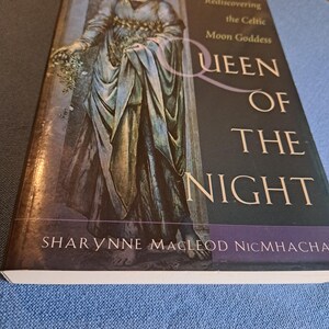 May include: A hardcover book titled "Queen of the Night" by Sharynne MacLeod NicMhacha. The cover features an illustration of a woman in a flowing gown, with text that reads "Rediscovering the Celtic Moon Goddess".