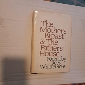 以下が含まれることがあります： リード・ホイットモア著「The Mother's Breast & The Father's House」というタイトルのハードカバー本。本は白い表紙に茶色の文字で書かれています。タイトルは大きく、様式化されたフォントです。