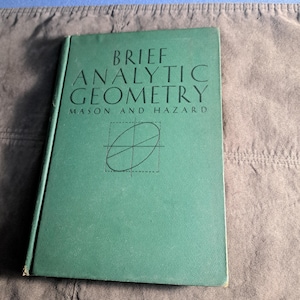 May include: A green hardback book titled "BRIEF ANALYTIC GEOMETRY" by MASON AND HAZARD. The cover features a black and white illustration of an ellipse on a graph.