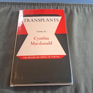 May include: A book titled "Transplants" by Cynthia Macdonald. The cover features a red and white geometric design with the title in white capital letters. The book is part of "The Braziller Series of Poetry."