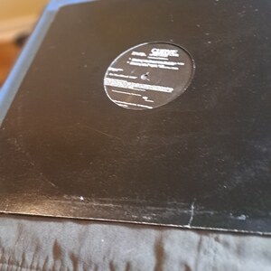 May include: Black vinyl record with a white label that says "CURVE -  SAINT VITUS"