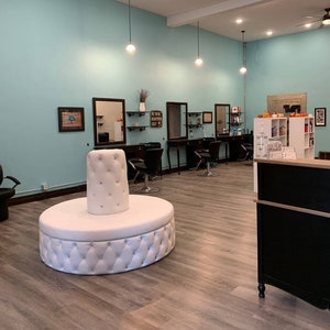 Round sofa tufted in white faux leather for a salon spa