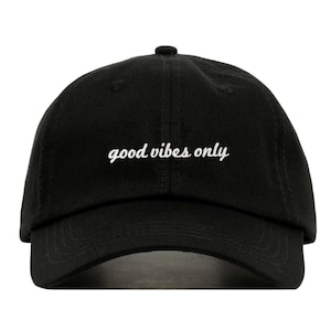 May include: A black baseball cap with white embroidered text that reads "good vibes only".