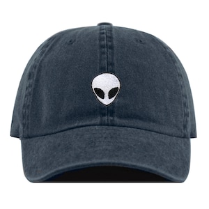 May include: A dark blue denim baseball cap with a white alien face embroidered on the front.