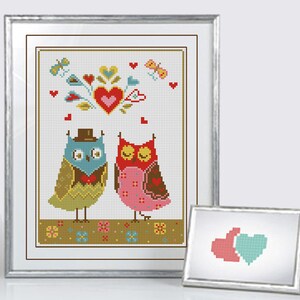 May include: Cross-stitch artwork featuring two owls, one in a top hat and bow tie, the other with a pink dress. The design includes hearts, butterflies, and floral elements, all framed in a silver border. A smaller framed image is also present.