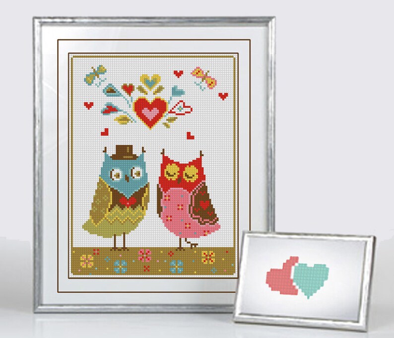 May include: Cross-stitch artwork featuring two owls, one in a top hat and bow tie, the other with a pink dress. The design includes hearts, butterflies, and floral elements, all framed in a silver border. A smaller framed image is also present.
