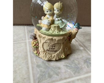 Love One Another Water Globe Plays "Love Will Keep Us Together" sitting on stump