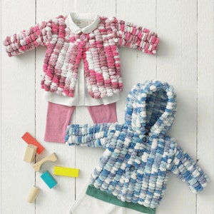May include: Image of a children's clothing set featuring a pink and white pom-pom jacket, a white collared shirt, and pink leggings. A blue and white hooded jacket and white pants are also shown. The text "SNUGGLY SWEETIE" is visible.