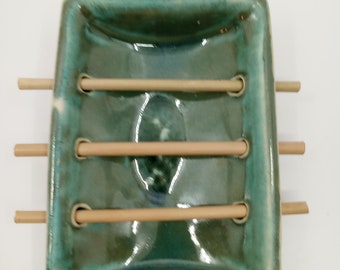 Handmade ceramic and bamboo soap dish with a small cactus pad imprint.