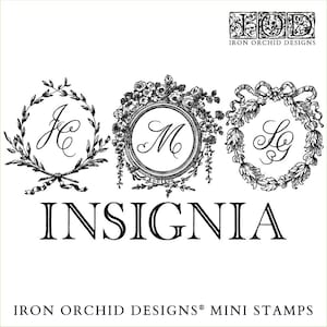 May include: Three black and white rubber stamps with ornate frames and initials "JC", "M", and "LG". The stamps are arranged horizontally and the word "INSIGNIA" is printed below them. The text "IRON ORCHID DESIGNS® MINI STAMPS" is printed below the word "INSIGNIA".