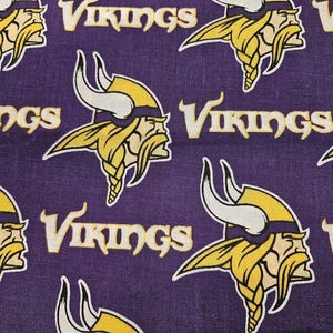 May include: Purple fabric with a repeating pattern of yellow Viking helmets and the word "Vikings" in white.