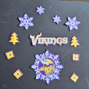 May include: Purple and yellow felt applique of a Viking helmet with horns inside a snowflake. The word "Vikings" is also included in yellow felt. There are also yellow felt Christmas trees and snowflakes.