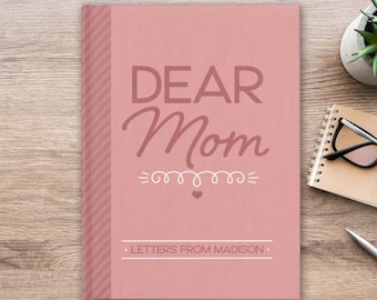 May include: Pink journal with the text "Dear Mom" in white lettering and a decorative swirl design. The text "Letters from Madison" is printed below the swirl design.
