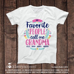 May include: White t-shirt with a pink, blue, and green floral design. The text "My Favorite People Call Me Grandma" is written in black. The names "Kelly, Sarah, Samuel, Madison" are written in black below the text.