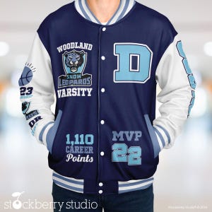 May include: A navy blue and white varsity jacket with the words "Woodland Snow Leopards Varsity" and "MVP 22" on the front. The jacket also features a blue letter "D" and a graphic of a snow leopard. The text "1,110 Career Points" is also on the jacket.