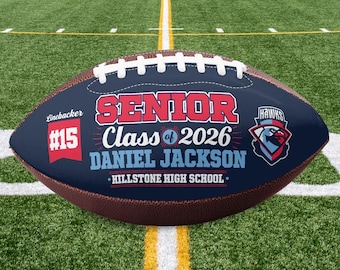 Könnte beinhalten: Ein personalisierter Football mit einem marineblauen Feld, das den Text "SENIOR Class of 2026" und den Namen "DANIEL JACKSON" trägt. Der Football zeigt auch die Nummer 15, den Namen der Hillstone High School und ein Hawks-Logo. Der Football ist braun und weiß.