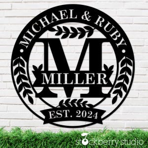 May include: Black metal sign with a wreath design and the text "MICHAEL & RUBY MILLER EST. 2024".