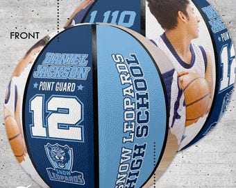 Może przedstawiać: Spersonalizowana piłka do koszykówki z wizerunkiem i nazwiskiem gracza, "Daniel Jackson, Point Guard, 12", oraz tekstem "Snow Leopards High School". Projekt zawiera niebiesko-białą kolorystykę i logo lamparta.