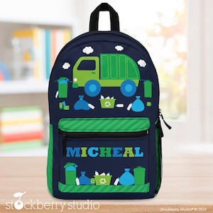 May include: Navy blue backpack with a green garbage truck design, blue wheels, and white clouds. The front pocket is green and blue striped, with the name "MICHEAL" in blue. Includes a side mesh pocket. Ideal for school.